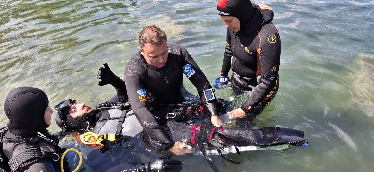 Команда допомагає учаснику адаптивного дайвінгу у воді